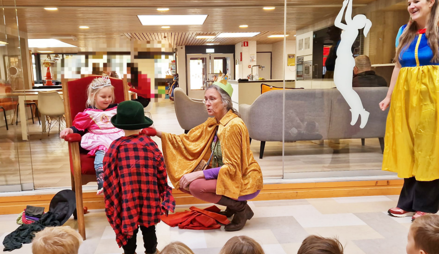 Juf Annette en twee kinderen in de rol van prins en prinses tijdens het thema sprookjes.