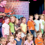 Kinderen zingen tijdens een optreden met TroefTheater