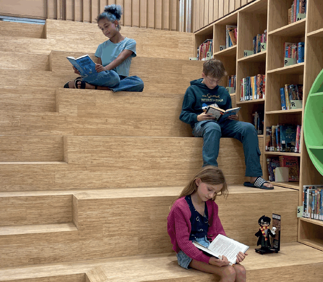 Leerlingen van IKC Remigius zitten te lezen in de schoolbibliotheek